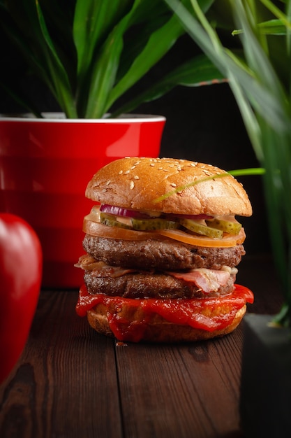 Foto hambúrgueres grelhados suculentos brilhantes com cogumelos e pepinos marinados em fundo de madeira. conceito de fast food