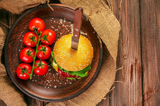 Hamburguesa apetitosa con tomates en la mesa