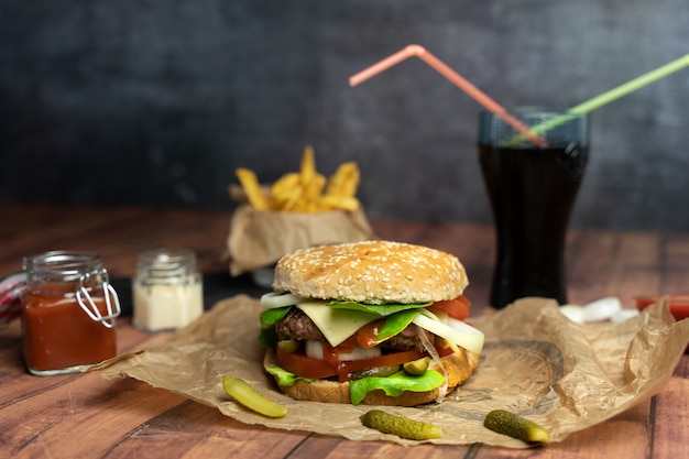 Hamburguesa artesanal con papas fritas y coca cola con pajitas