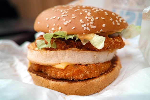 Una hamburguesa con un bollo de semillas de sésamo y lechuga.