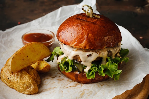 hamburguesa de carne jugosa de comida rápida o hamburguesa con queso con papas fritas y salsa