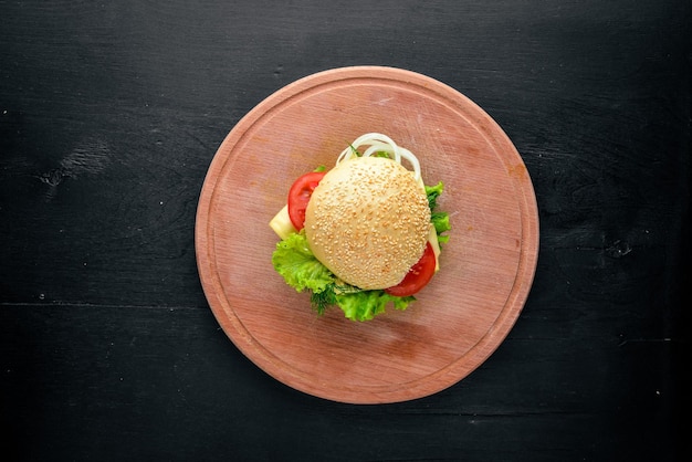 Hamburguesa con carne de queso y cebollas verdes sobre fondo de madera Vista superior Espacio libre