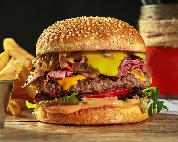 Hamburguesa con carne de res, jamón, queso, cebolla caramelizada y tomates