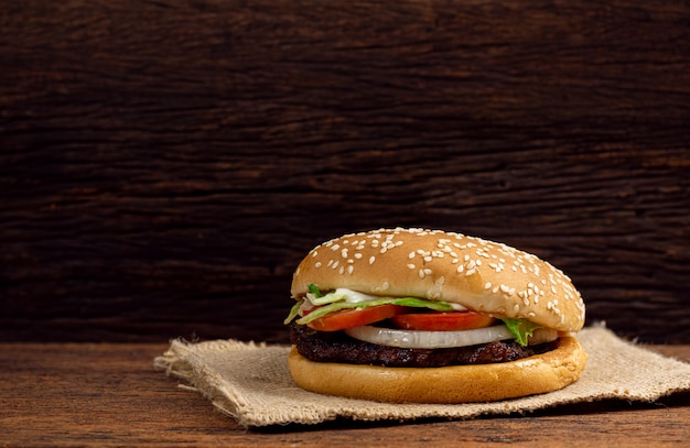 Hamburguesa de carne y verduras sobre fondo de madera