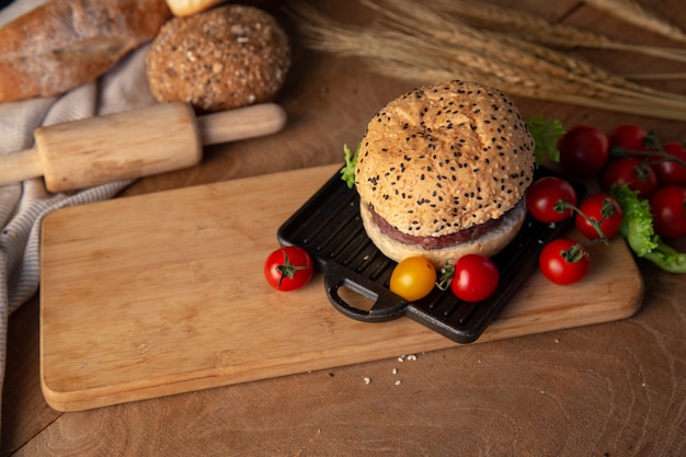 Hamburguesa casera en mesa de madera.