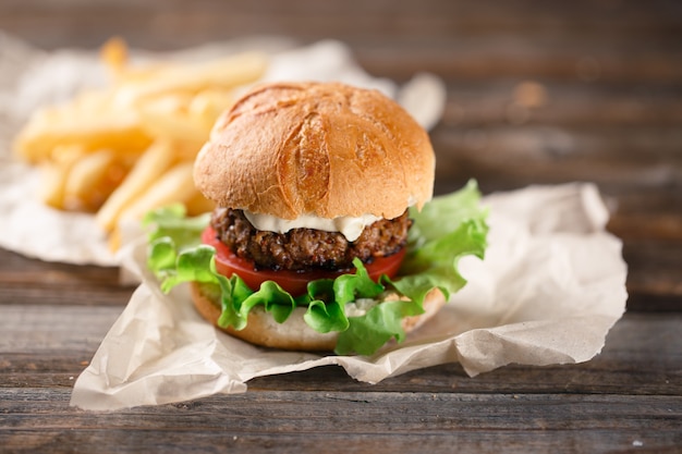 Hamburguesa casera con papas fritas en mesa de madera