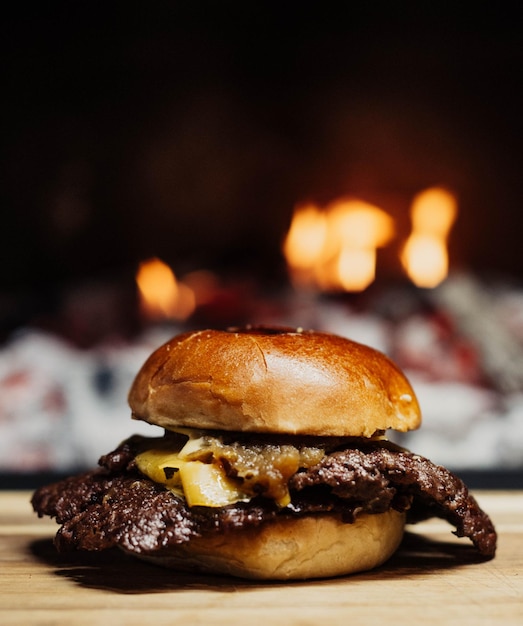 Una hamburguesa con cebolla y queso se asienta sobre una tabla para cortar.