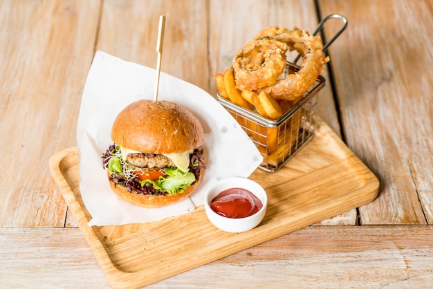 Hamburguesa de cerdo con aros de cebolla y papas fritas.