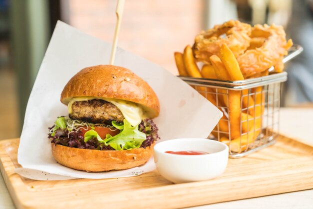 Hamburguesa de cerdo con aros de cebolla y papas fritas.