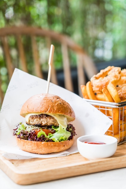 Hamburguesa de cerdo con aros de cebolla y papas fritas.