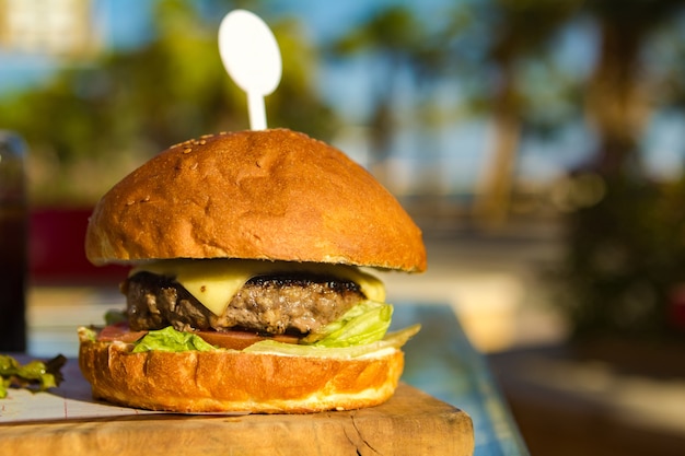 Hamburguesa con una chuleta en una tabla de madera en un restaurante cafetería