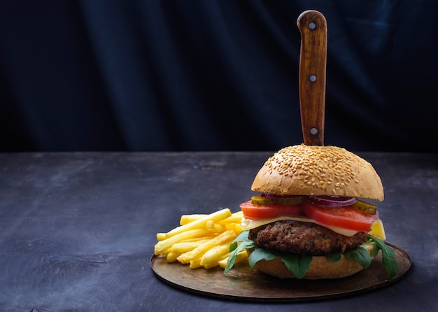 Hamburguesa con chuleta, tomate, queso y papas fritas.