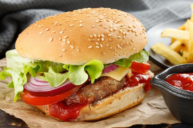 Hamburguesa con chuleta tomate queso y verduras fresca sabrosa hamburguesa aislado sobre fondo negro