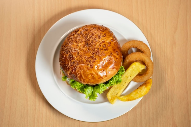 Hamburguesa clásica tradicional servida en un plato blanco sobre un fondo negro Hamburguesa de carne plana