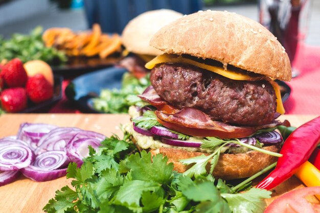 Foto hamburguesa de comida rápida hamburguesa deliciosa con tiras de carne frita lechuga de tomate y cebolla crujiente pan de harina de trigo blanco con semillas de sésamo tema de la comida