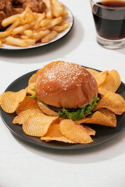 Hamburguesa de comida rápida con pollo frito crujiente y papas fritas, cola de hielo en el lateral