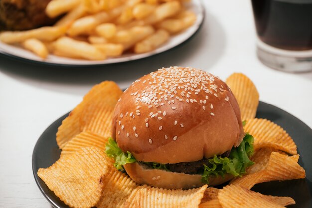 Hamburguesa de comida rápida con pollo frito crujiente y papas fritas, cola de hielo en el lateral