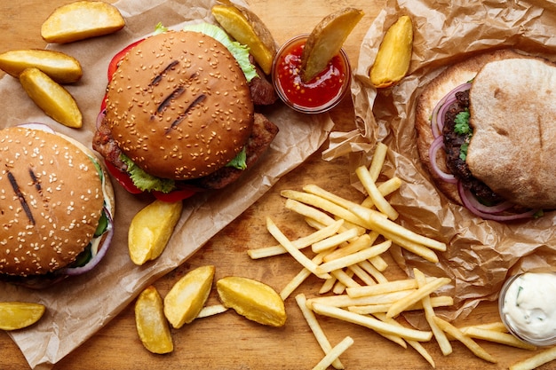 Foto hamburguesa y cuñas en bandeja de madera