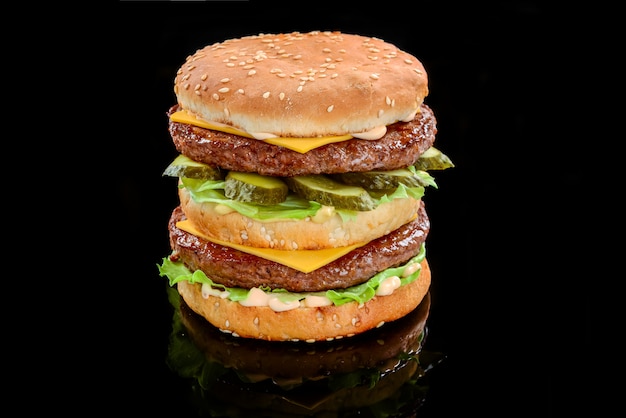 Una hamburguesa doble con queso de estilo clásico con dos empanadas de carne, salsa, lechuga, queso, pepinillos y cebollas en un panecillo de semillas de sésamo