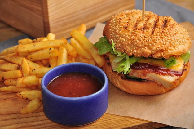 Hamburguesa con filete de pollo, salsa de tomate y papas