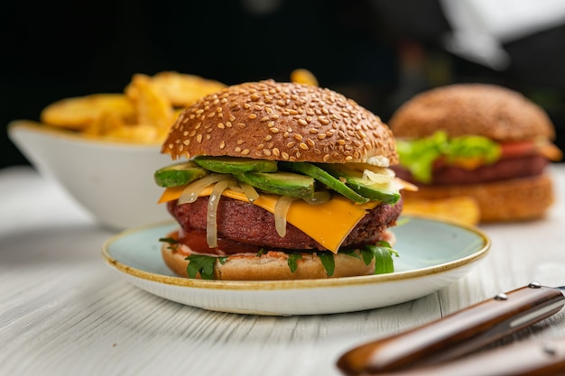 Hamburguesa fresca con carne y verduras veganas, espolvoreada con semillas de sésamo