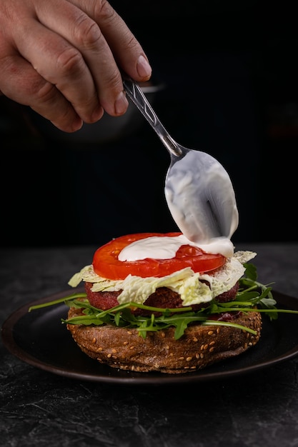 Hamburguesa fresca con carne y verduras veganas, espolvoreada con semillas de sésamo