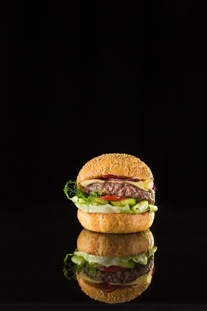 Hamburguesa fresca con chuleta de ternera sobre un fondo negro