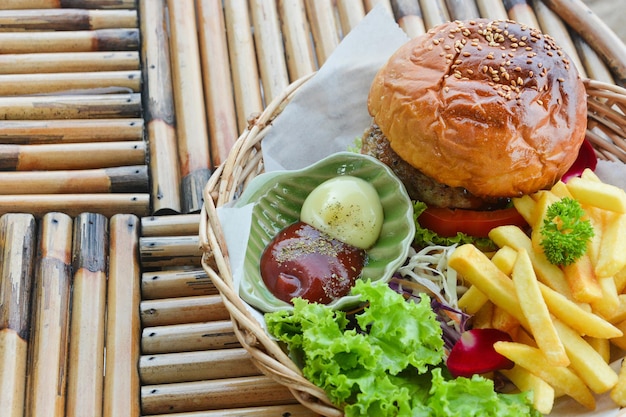 Hamburguesa fresca con papas fritas en mesa de madera