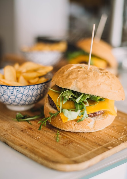 Hamburguesa gourmet con queso servida con pan casero y acompañada de papas fritas