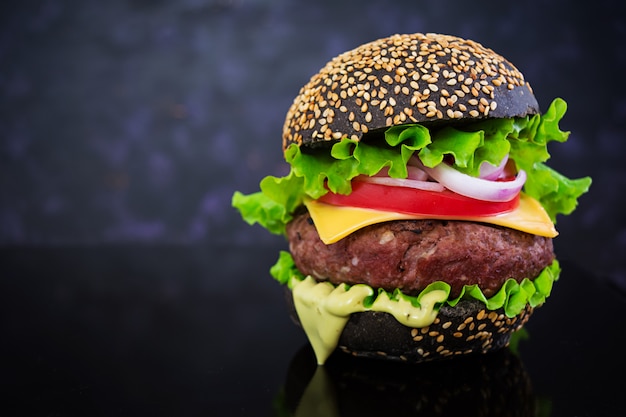 Hamburguesa hecha a mano sobre una superficie oscura. Deliciosa hamburguesa negra