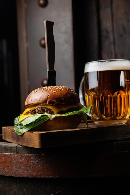 Una hamburguesa y una jarra de cerveza en una mesa.