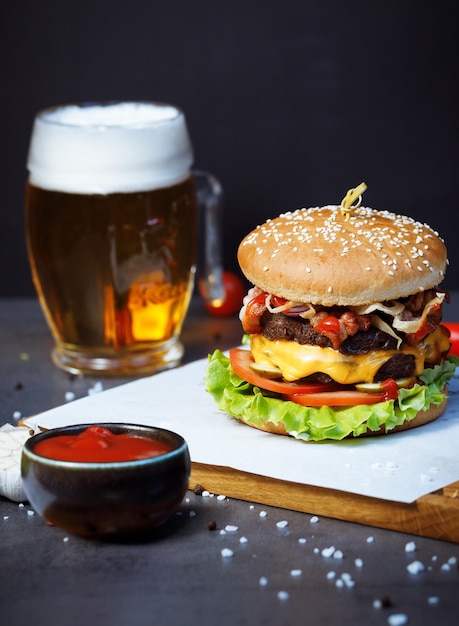 una hamburguesa con ketchup y una pinta de cerveza sobre la mesa
