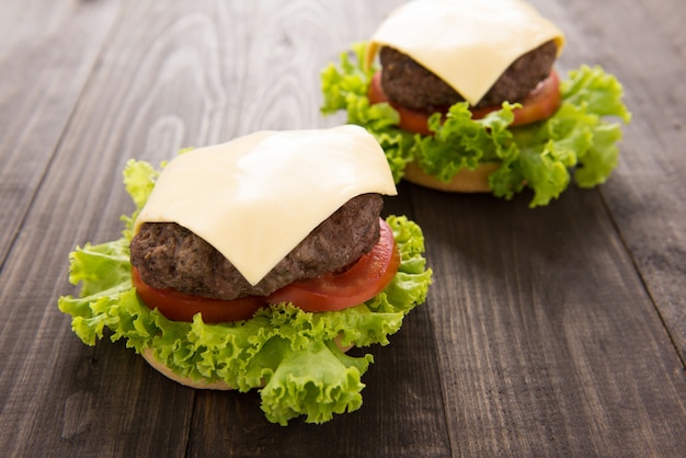 Hamburguesa con lechuga y queso en mesa de madera