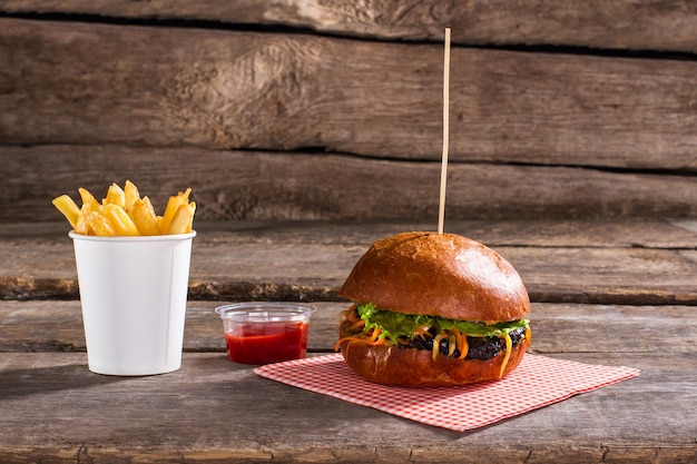 Hamburguesa en palo con papas fritas.