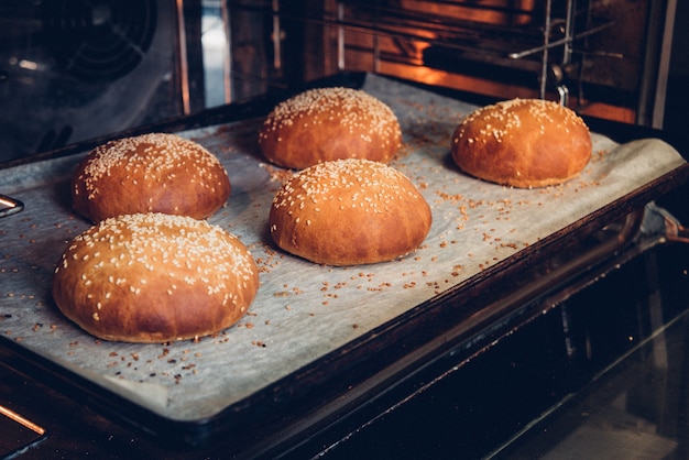 Hamburguesa de pan fresco dorado con semillas de sésamo en el horno.