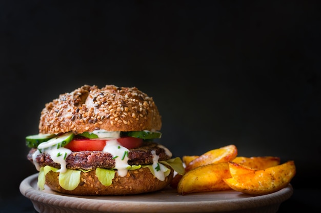 una hamburguesa con un pan y papas fritas en un plato.