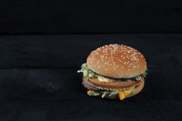 Hamburguesa con pan de sésamo sobre fondo negro