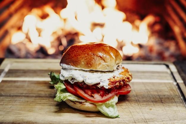 Una hamburguesa con pan y tomate encima.