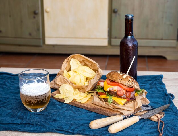 Hamburguesa y papas fritas Comida poco saludable para comer en casa en la sala de estar un placer después de un día de trabajo