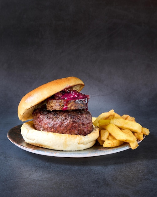 hamburguesa con papas fritas en el fondo de la pizarra