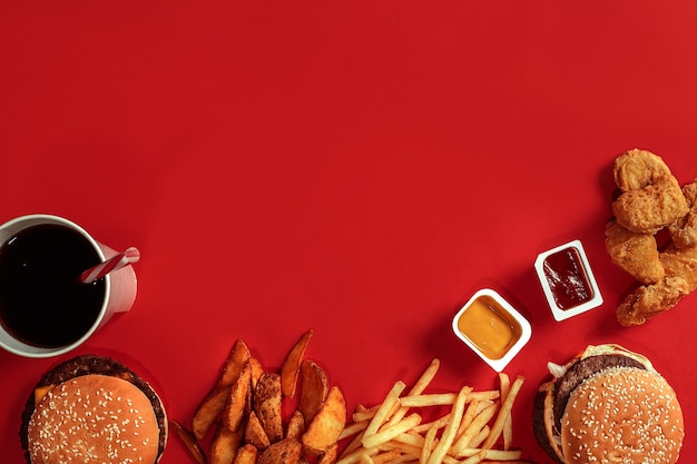 Hamburguesa y papas fritas hamburguesa y papas fritas en caja de papel rojo comida rápida sobre fondo rojo.