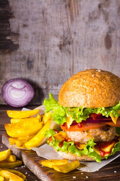 Hamburguesa y papas fritas en una mesa de madera