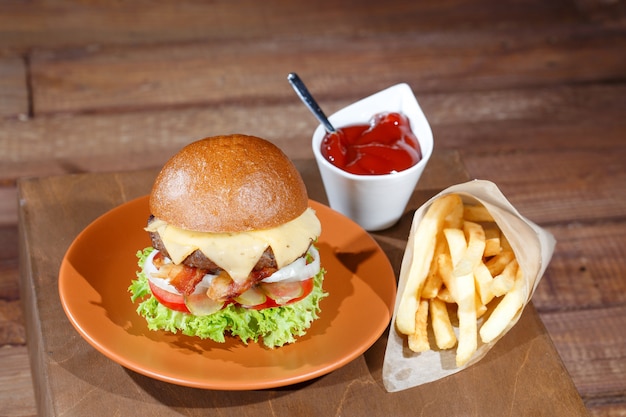 Hamburguesa y papas fritas en la mesa de madera.