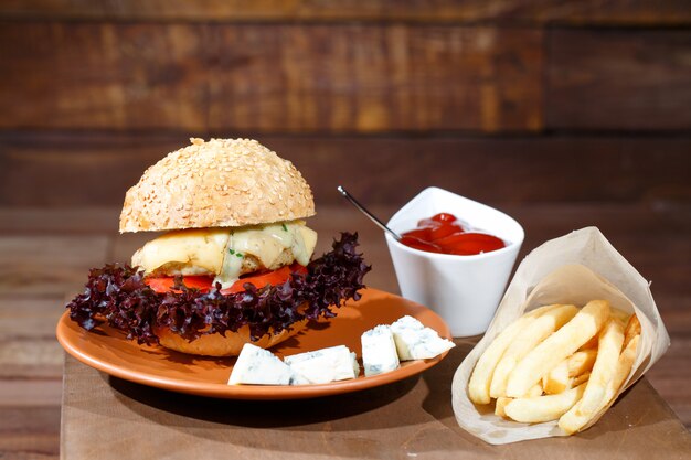 Hamburguesa y papas fritas en la mesa de madera.