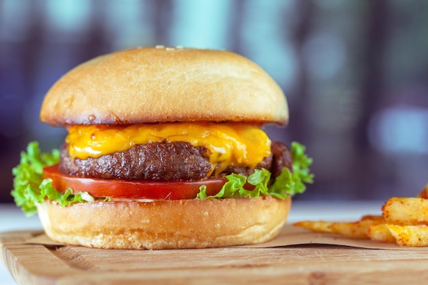 Hamburguesa y papas fritas en mesa de madera