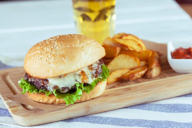 Hamburguesa y papas fritas en mesa de madera