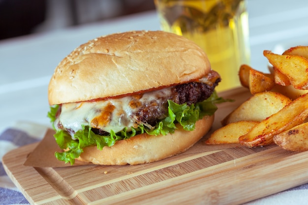 Foto hamburguesa y papas fritas en mesa de madera