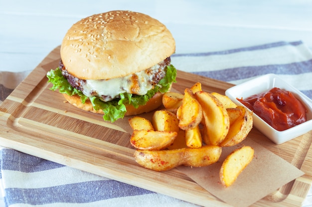 Hamburguesa y papas fritas en mesa de madera