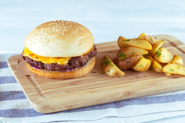 Foto hamburguesa y papas fritas en mesa de madera