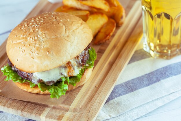 Hamburguesa y papas fritas en la mesa de madera